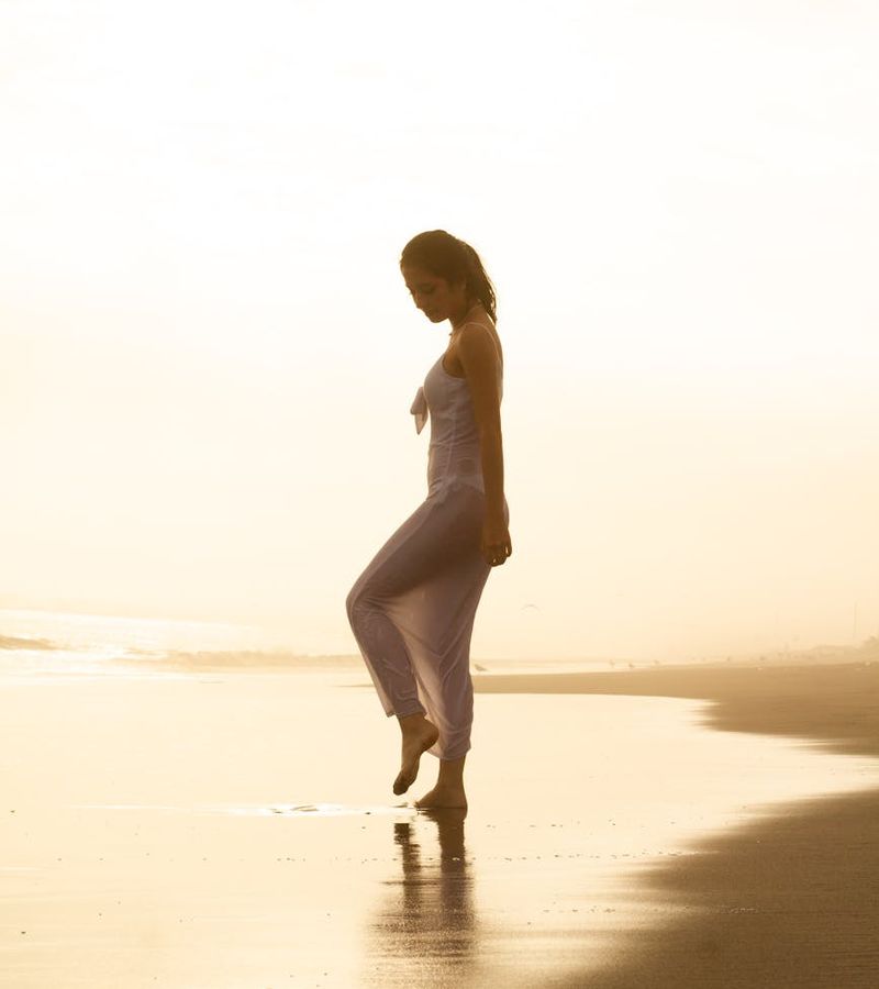 Elegant silhouette in a meditation pose with golden light radiating outwards.